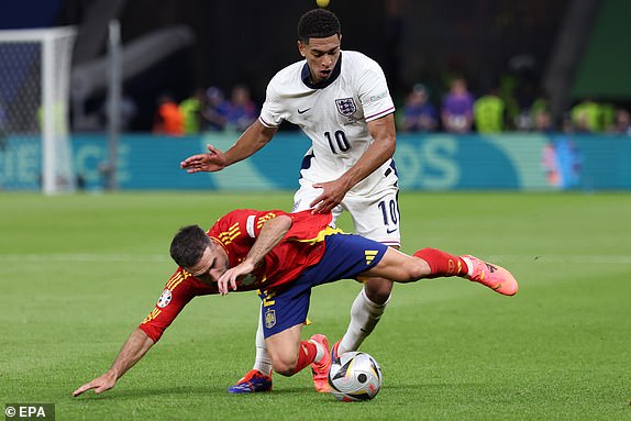 epa11478469 Dani Carvajal of Spain (down) in action against Jude Bellingham of England during the UEFA EURO 2024 final soccer match between Spain and England, in Berlin, Germany, 14 July 2024.  EPA/CHRISTOPHER NEUNDORF