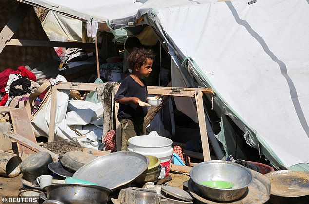 A child walks amid the damage following an Israeli strike at a tent camp in Al-Mawasi area