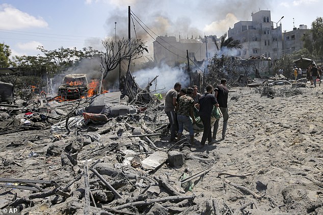 Palestinians evacuate a body from a site hit by an Israeli bombardment on Khan Younis, southern Gaza Strip, Saturday, July 13, 2024