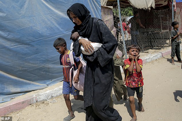 A crying mother and her children evacuate the area of the Israeli bombardment in Khan Younis, southern Gaza, on July 13, 2024