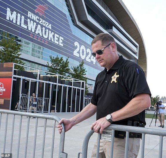 A United States Secret Service officer moves barricades outside the Fiserv Forum ahead of the 2024 Republican National Convention, Saturday, July 13, 2024, in Milwaukee. Former president Donald Trump was whisked off the stage at a rally in Butler, Pennsylvania after apparent gunshots rang through the crowd.(AP Photo/Morry Gash)