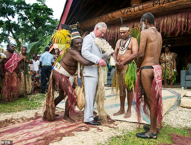 Charles is given a grass skirt to wear prior to receiving a chiefly title during a visit to the Chiefs' Nakamal during a visit to the South Pacific Island of Vanuatu