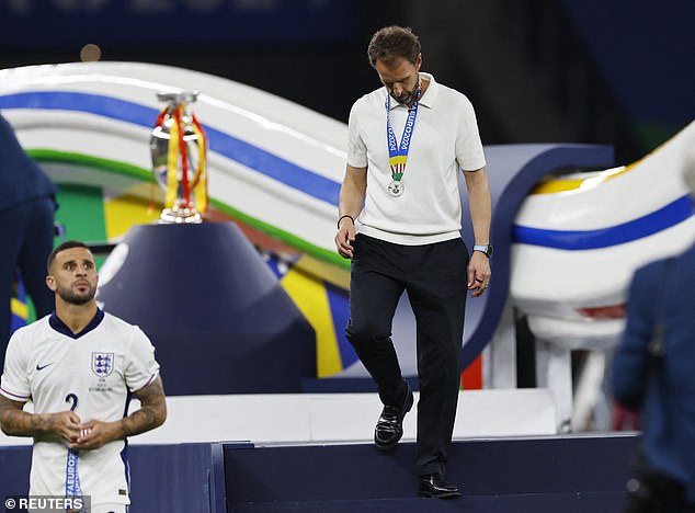 And England manager Gareth Southgate appeared dejected as he collected his runner-up medal, watched on by defender Kyle Walker, left