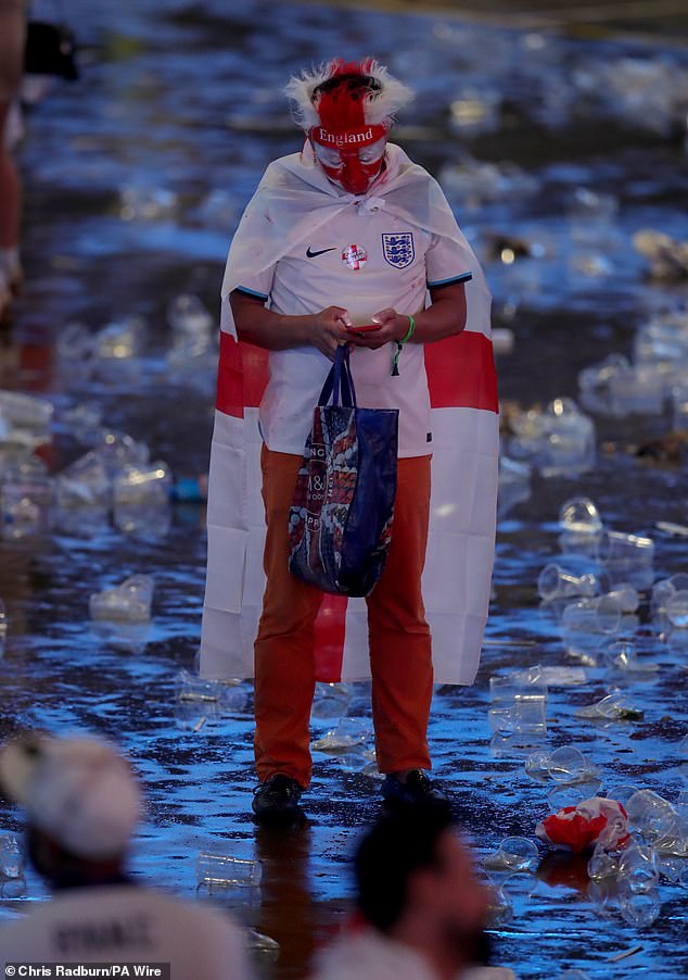 An England fan cuts a lonely figure as they make their way out of the O2 looking down at their phone