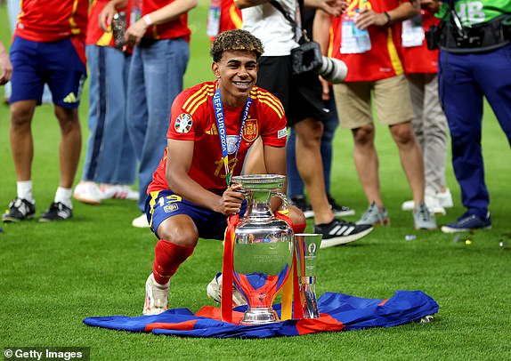 BERLIN, GERMANY - JULY 14: Lamine Yamal of Spain celebrates with the UEFA Euro 2024 Henri Delaunay Trophy after his team's victory in the UEFA EURO 2024 final match between Spain and England at Olympiastadion on July 14, 2024 in Berlin, Germany. (Photo by Richard Pelham/Getty Images)