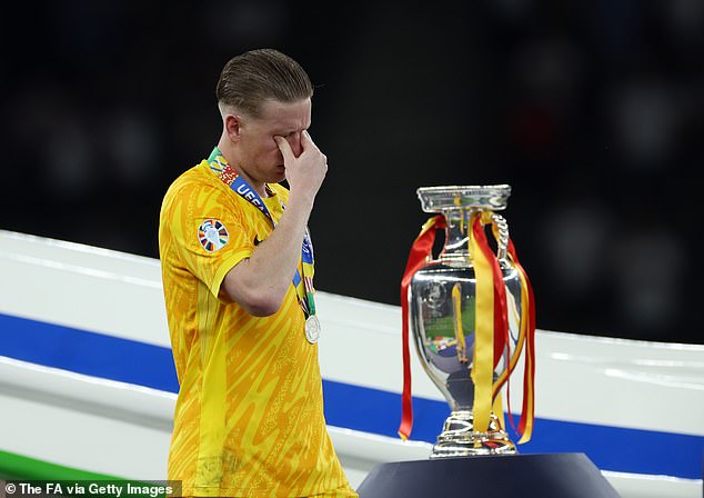 PIckford appeared to wipe tears from his eye as he walked past the winners' trophy