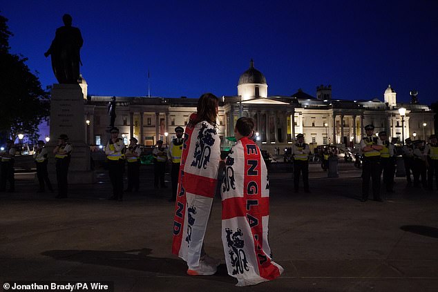 Two England fans wearing flags were seen comforting each other in Trafalgar Square, where hours earlier hundreds of supporters had been cheerfully singing and drinking beer