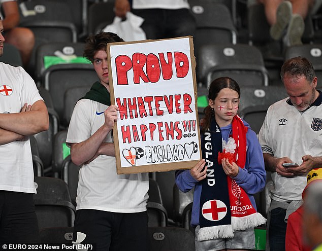 Dejected looking fans held up a sign saying 'Proud whatever happens' after England's loss against Spain