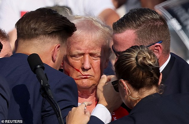 Trump is seen surrounded by Secret Service agents in the moments after the shooting. He raised his fist to indicate that he was okay in an image that has since swept the globe