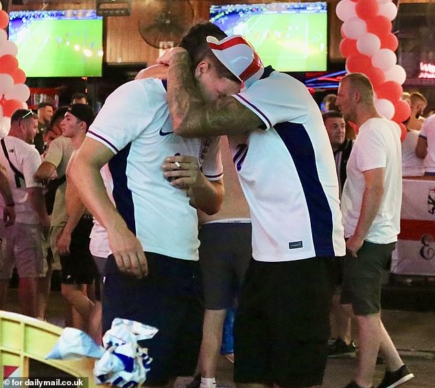 Two England fans embrace after the Three Lions' crushing 2-1 defeat to Spain in the Euros final