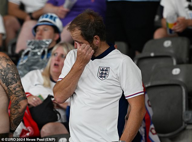 BERLIN -- A fan wipes his eye following England's loss to Spain