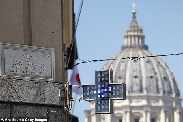 A pharmacy's signboard shows the external temperature as St. Peter's Dome is seen in background during an intensely hot day in Rome, Italy, on July 11, 2024