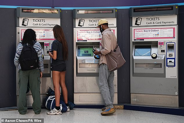 Passengers buying tickets at Victoria train station, London, amid reports of widespread IT outages affecting airlines