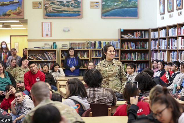 A service member speaks with students at a school in Alaska, one of the lowest performing states in the country