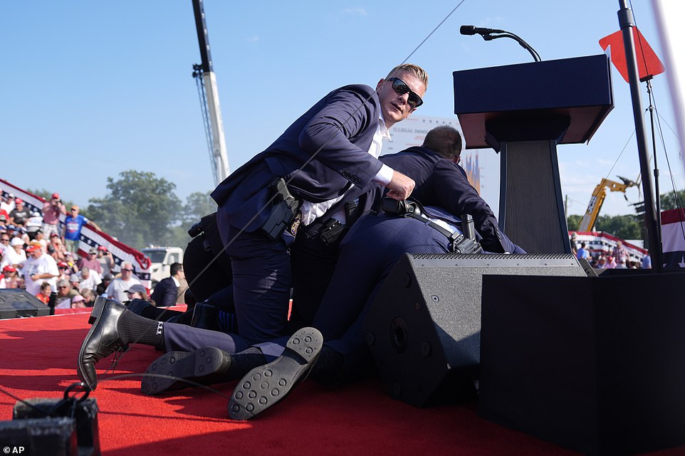 He added: 'They thought it was over when I went down because they saw the blood immediately and then when I put the hand up everybody was happy. That was the time when they realized I was ok.' Trump, who pumped his first at the crowd and appeared to mouth the word 'fight', was met with chants of 'USA' and ' Make America Great Again' . He has now praised the crowd for being 'brave' and hailed America as an 'incredible country'. 'It was a beautiful moment,' he said of the aftermath. 'The people on the stage were unbelievable and brave they were running past bullets. 'They were all Secret Service that came running up and they were running past me with bullets - when I went down, bullets were coming over my head and you hear them, it's like a zip, zip.'