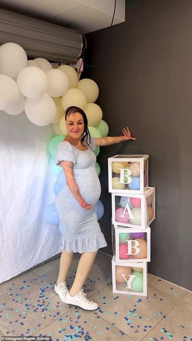 The expectant mum changed into a fitted blue dress to mark the baby's sex, cradling her bump as she posed alongside the baby blocks