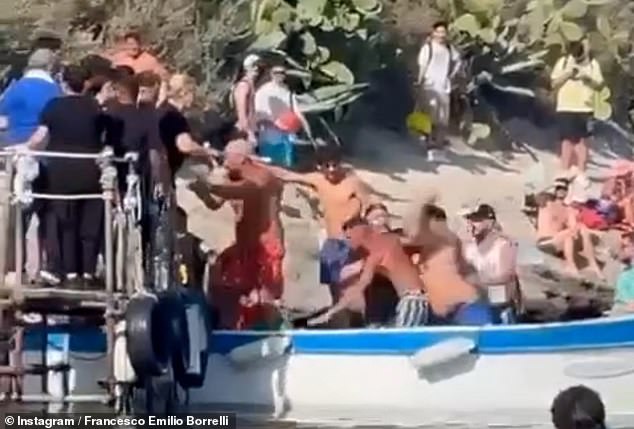 The fight quickly extended from the boat to the pier as the men in swimming gear threw kicks and punches at one another