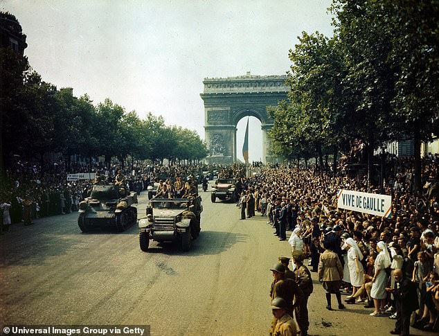 Allied tanks and other army vehicles in the Champs-Elysees during the liberation parade in August 1944 as cheering crowds watch on