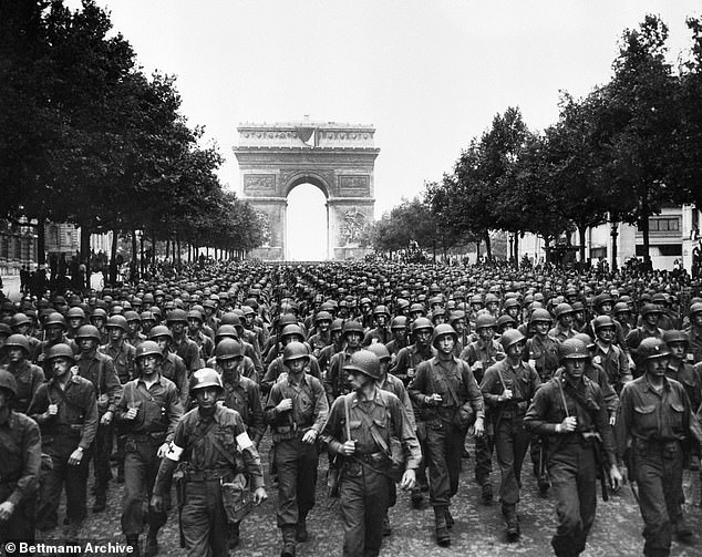 American troops marching down the Champs-Elysees in Paris with the Arc de Triomphe in the background