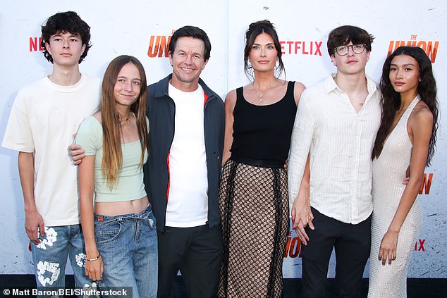 Mark Wahlberg's son Michael flashed his chest tattoo while posing with father, Mark, 53, mum Rhea, 46, siblings Brendan Joseph, 15, Grace Margaret, 18, and girlfriend Sunni Gaines, to rock the red carpet at the premiere of The Union, in Los Angeles