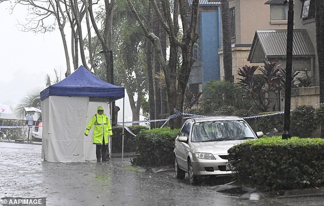 A 46-year-old woman has been arrested and charged with murder. Police are seen at the scene on Wednesday