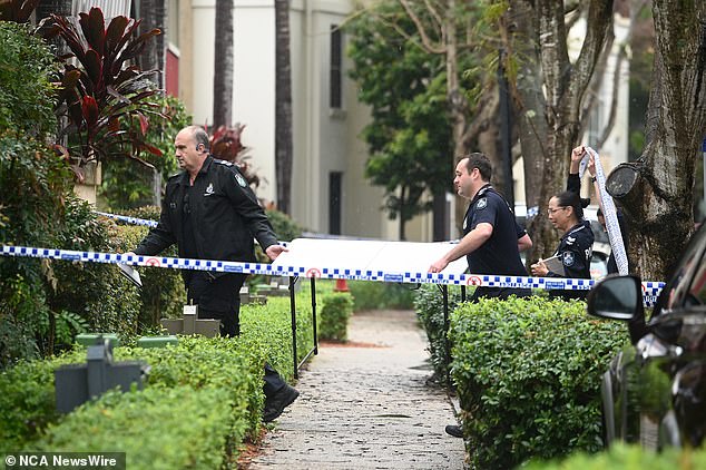 Queensland Police officers are seen at the unit where the 10-year-old was found