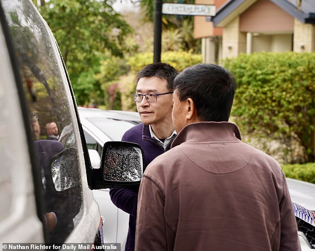 Professor Wang's colleagues are pictured speaking to detectives at the crime scene on Wednesday