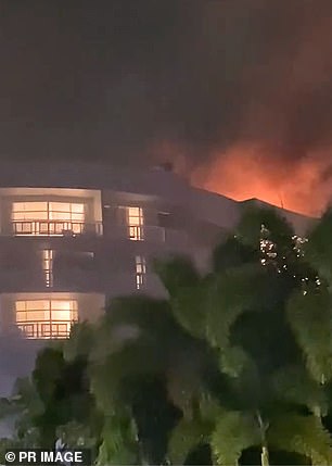 Fire erupts atop the Cairns hotel  after Blake Wilson crashed the helicopter into the roof