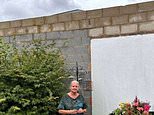 Couple hit out at next door's new 'prison wall' they say is blocking their sunlight - as neighbour says planning row has left her unable to live in her house