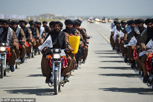 Taliban military personnel carrying a dummy yellow canister, intended to resemble homemade explosives, parade to celebrate the third anniversary of Taliban's takeover of Afghanistan