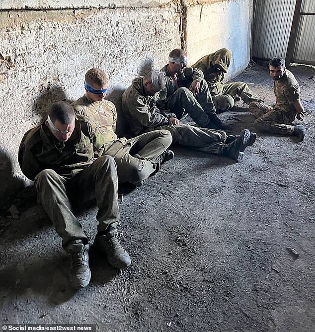 Several soldiers were sitting on the ground with blindfolds on after they surrendered