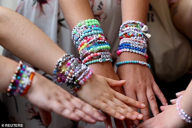 Swifties have been trading - often hundreds of - the bright and colourful beaded bracelets at her concerts. Pictured: Fans with bracelets ahead of her Wembley concert on Thursday