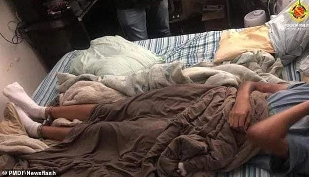 Picture shows the girl, 12, with her legs handcuffed, lying on a bed in the suspect's apartment