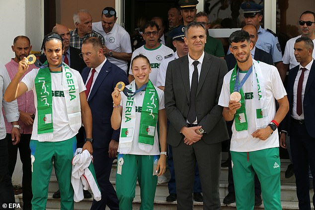 Khelif (front left) poses with her new gold medal on her return to Algeria with her Olympic team-mates