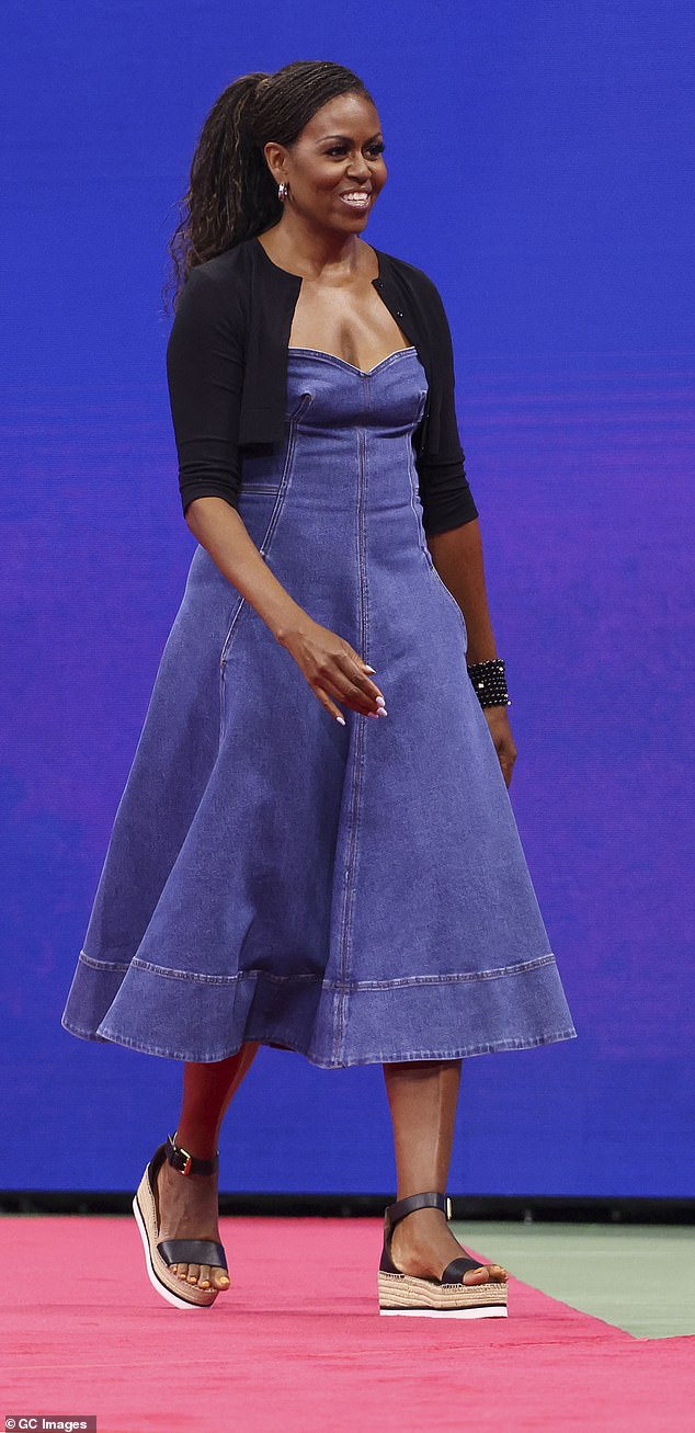 Michelle Obama wore a denim blue dress boasting an A-line silhouette topped with a black cardigan sweater