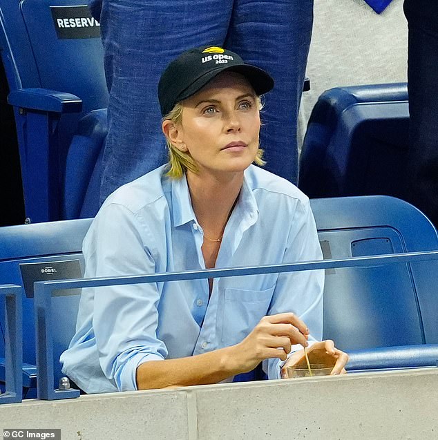 The 'Mad Max' actress donned a crisp baby blue button down that brought out her sparkling blue eyes and accessorized with a U.S. Open baseball cap