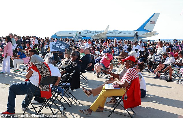 Supporters gathered on the tarmac outside of the hangar the Air Force Two in the background attend a campaign rally with US Vice President and Democratic presidential candidate Kamala Harris