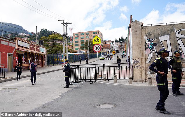 Police stand guard at a cordon outside La Giralda school in the Santa Fe district of Bogota today