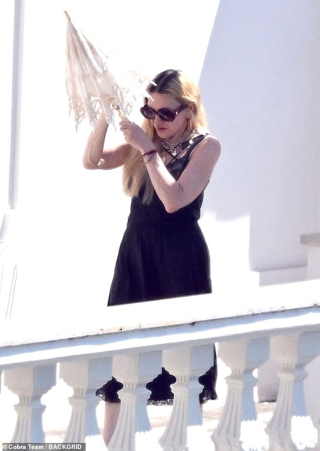 When she wasn't sailing, Madonna could be seen trying to beat the heat while out on the balcony of a gorgeous white building