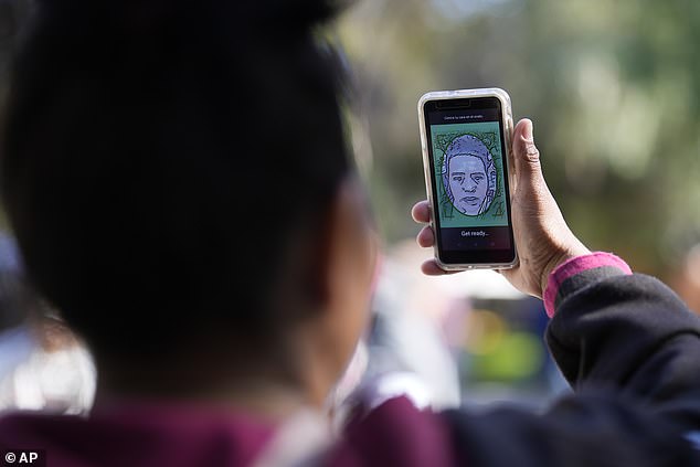 A migrant from Michoacan, Mexico, uses the CBPOne app Tuesday, Jan. 24, 2023, in Tijuana, Mexico