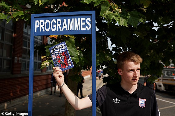 IPSWICH, ENGLAND - AUGUST 17: A programme seller is seen outside the stadium prior to the Premier League match between Ipswich Town FC and Liverpool FC at Portman Road on August 17, 2024 in Ipswich, England. (Photo by Julian Finney/Getty Images)