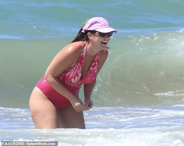 Meanwhile at the beach, Jacqueline looked as happy as ever as she soaked up the sunshine, accessorising her holiday look with a purple cap and dark sunglasses