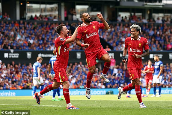 IPSWICH, ENGLAND - AUGUST 17: Mohamed Salah of Liverpool celebrates scoring his team's second goal with teammates Diogo Jota and Luis Diaz during the Premier League match between Ipswich Town FC and Liverpool FC at Portman Road on August 17, 2024 in Ipswich, England. (Photo by Marc Atkins/Getty Images)