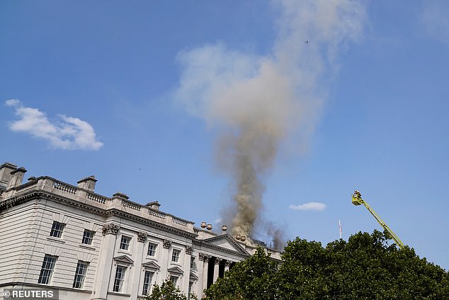 Smoke rises as firefighters work at the scene of a fire at Somerset House in London today