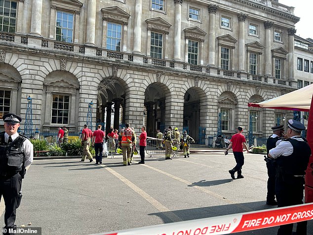 Firefighters wearing breathing apparatus enter Somerset House's courtyard after a fire took hold earlier today