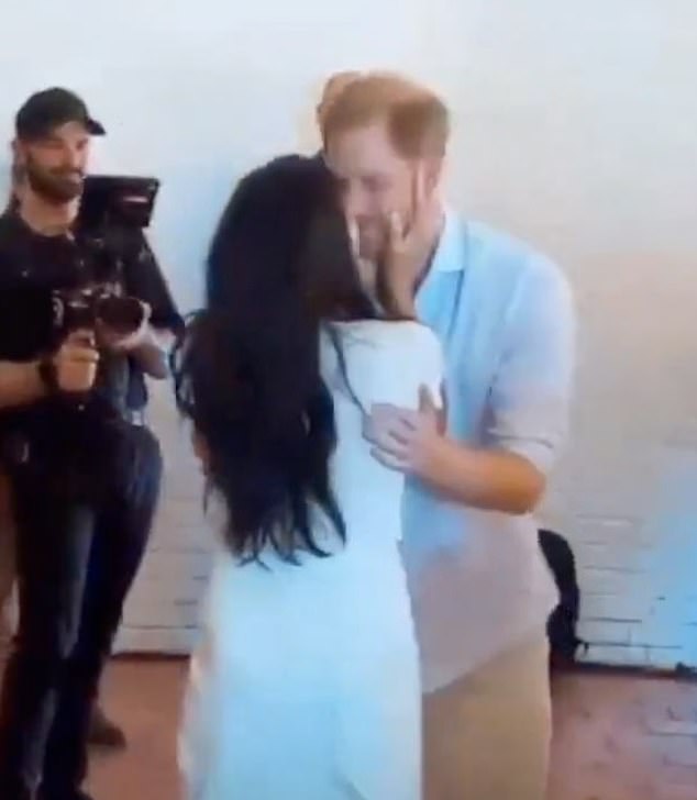 Meghan reached out to grab Harry's face with both hands, pulling him in for a smack on the lips