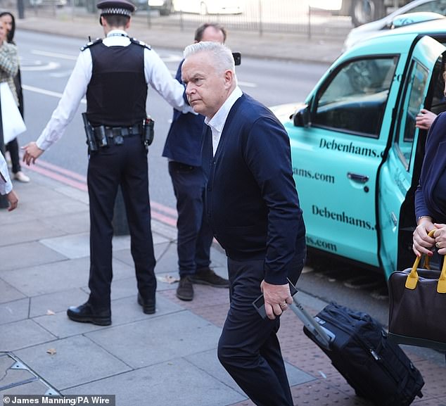 Edwards arrives at Westminster Magistrates' Court in London this morning with a wheelie suitcase