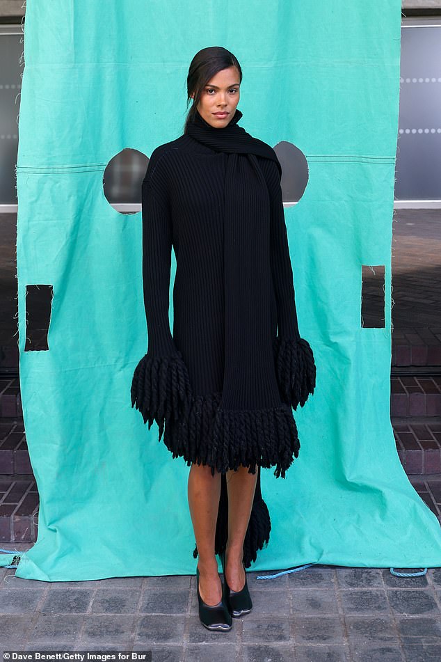 Tina Kunakey smouldered in a knitted black dress that boasted a matching scarf and fringe detailing on the sleeves and hem