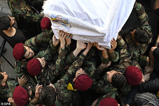 Hezbollah fighters carry a coffin of one of the people who died a day earlier in pagers blasts, during the funeral procession in the southern suburb of Beirut, Lebanon