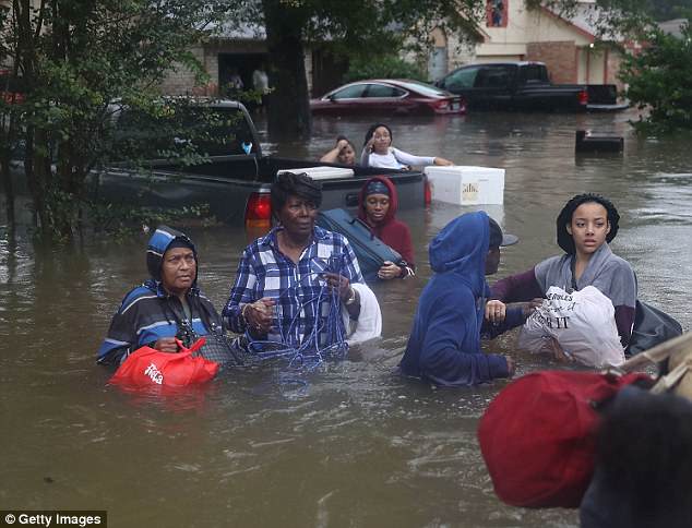 Homes were destroyed and families stranded as water overtook the state, a family evacuating their flooded neighborhood in Houston on August 28